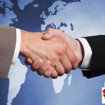 Businessmen Shaking Hands Against Worldmap
